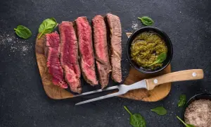 Perfekt gegrilltes Porterhouse Steak, in Scheiben geschnitten, mit Pesto und Kräutersalz.