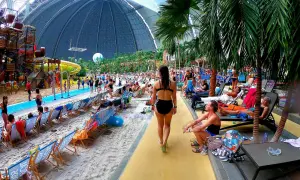 Tropikalny raj w aquaparku pod Berlinem. Ludzie odpoczywają na plaży pod ogromną kopułą, wśród palm i zjeżdżalni.