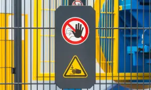 Tablica ostrzegawcza z zakazem zbliżania się i symbolem zgniecenia dłoni. Informuje o ryzyku rezydualnym przy obsłudze maszyny.