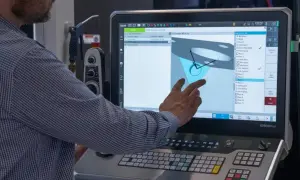 Operator pracuje nad sinumerik programowanie, dotykając ekranu z modelem 3D i listą operacji.