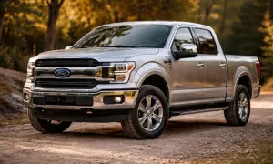 Srebrny pickup Ford F-150 na leśnej drodze.