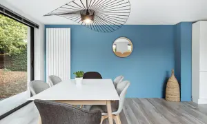 Un mur bleu vif illumine cette salle à manger moderne. Quel mur peindre en couleur ? Celui-ci, sans hésiter !