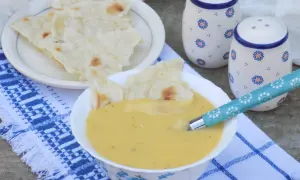 Aksamitna zupa krem z ziemniaków, podana z chrupiącym pieczywem. Idealna na chłodne dni.