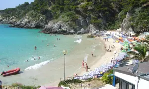 Spiagge delle Isole Tremiti raggiungibili a piedi, con acque cristalline e gente che si gode il sole sotto gli ombrelloni.