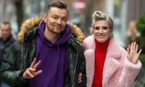 Sylwia Grzeszczak i Liber uśmiechają się do obiektywu, ona macha ręką, on pokazuje znak pokoju.
