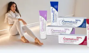 Kobieta w białym stroju siedzi obok tubek z kremami Cremobaza 10%, 30% i 50%.