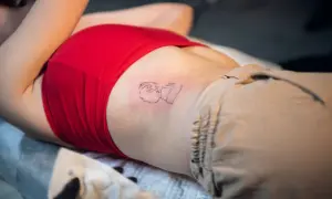 Nowy tatuaż na żebrach, przedstawiający abstrakcyjną postać.