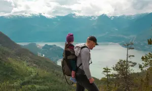 Ojciec z dzieckiem w nosidle na tle gór. Gdzie w Tatry? To pytanie zadaje sobie wielu, ale ten widok zapiera dech w piersiach.
