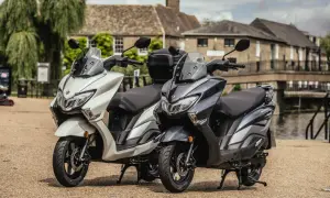 Dwa skutery Suzuki Burgman 125, jeden biały, drugi grafitowy, stoją obok siebie. Sprawdź suzuki burgman 125 cena!