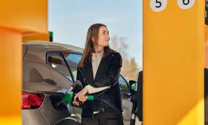 Kvinna tankar sin bil med hvo diesel vid en gul pump.