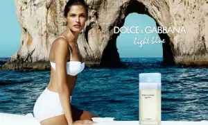 Kobieta w białym bikini na tle skalistej zatoki. Obok flakon perfum Dolce & Gabbana Light Blue.