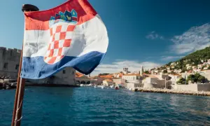 Chorwacka flaga na tle Dubrownika. Planujesz podróż? Sprawdź, co zabrać do Chorwacji jadąc samochodem.