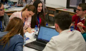 Jóvenes participan en actividades para trabajar la asertividad en el aula, colaborando en un proyecto.