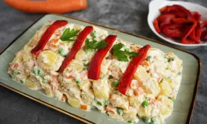Spanischer Kartoffelsalat mit Thunfisch und Mayonnaise, garniert mit Paprika und Petersilie. Ein köstlicher Genuss!