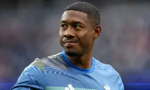 Piłkarz David Alaba w niebieskiej koszulce z białym logo Adidas i herbem Realu Madryt.