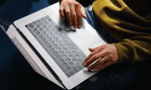 Person arbetar på laptop, kanske bokför bokföring för avdrag enskild firma.