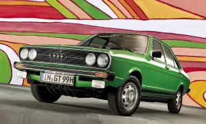 Grön Audi 50 står framför en färgglad, abstrakt bakgrund. Bilen har en klassisk design med kromdetaljer och en svart rand längs sidan.