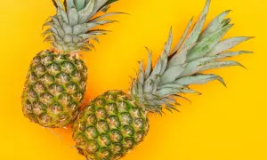 Dwa ananasy na żółtym tle. Czy pies może ananasa? To pytanie nurtuje wielu właścicieli czworonogów.
