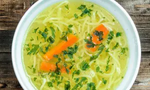 Aromaticzny rosół z makaronem, marchewką i natką pietruszki. Czy rosół ma białko? Tak, dzięki mięsu, z którego jest gotowany, dostarcza cennego białka.