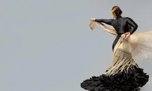 Bailarina con traje de flamenca negro y mantón bordado. Un ejemplo de cómo planchar un traje de flamenca para que luzca impecable.