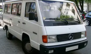 Biały Mercedes MB 100 D zaparkowany na ulicy. Klasyczny van z lat 90.