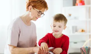 Babcia z wnukiem przeglądają karty, ucząc się rozpoznawać różne rzeczy. To świetny sposób na rozwijanie wiedzy i zapobieganie stereotypie u dzieci.