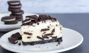 Ein cremiges Stück Oreo Cheesecake mit zerbröselten Keksen und Sahne.