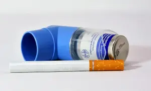 Niebieski inhalator leżący na papierosie.