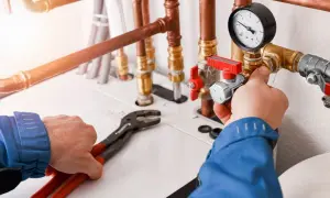 Instalator reguluje zawór przy kotle gazowym, dbając o efektywne ogrzewanie i niskie koszty.