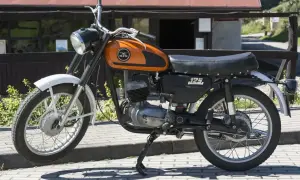 Pomarańczowy motocykl WSK 125 modele, klasyk z lat 70., gotowy do podróży.