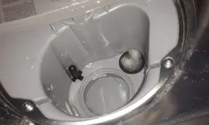 Zmywarka Beko, błąd E01. Widoczny filtr i odpływ z resztkami jedzenia, które mogą powodować problem.