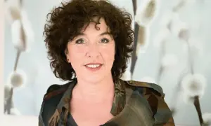 Roos Vonk, met haar kenmerkende krullen, lacht naar de camera. Op de achtergrond zachte, pluizige katjes.