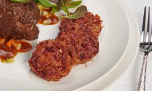 Herzhaftes Rinderfilet mit einer Beilage aus knusprigen rote Bete puffer und frischem Salat.