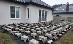 Budowa tarasu z deski kompozytowej na bloczkach betonowych. Podkład z agrowłókniny chroni przed chwastami.
