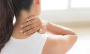 Frau mit schmerzender **Stiernacken** massiert ihren Nacken.
