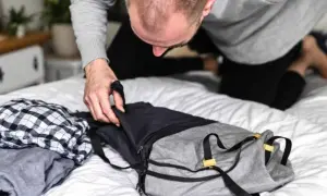 Un homme prépare son sac. Il se demande combien de kilo dans un sac de 30l peut contenir pour son voyage.