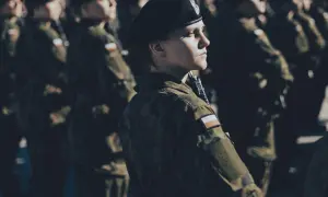 Kobieta w beretce i mundurze, gotowa do służby. To jej dobrowolna zasadnicza służba wojskowa.
