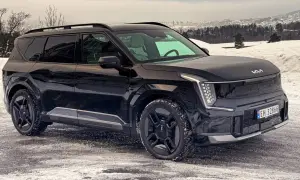 Svart Kia EV9 på en snöig väg, redo för ett vintertest. Bilen har en modern design med distinkta LED-lampor.