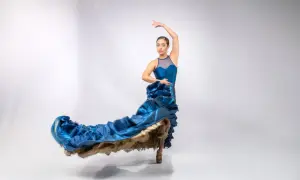 Bailarina con vestido azul ondeante, capturando la pasión y el arte de donde viene el flamenco.