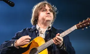 Lewis Capaldi gra na gitarze, mimo swojej choroby, z pasją i zaangażowaniem.