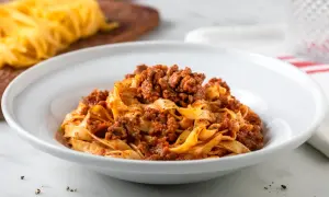 Tagliatelle al ragù, un classico delle ricette italiane, servite in un piatto bianco.
