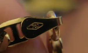 Cierre de cadena de oro con el sello 750, indicando alta pureza.