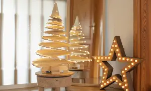Drewniane ozdoby świąteczne zrób to sam: spiralna choinka z lampkami i duża gwiazda z żarówkami.