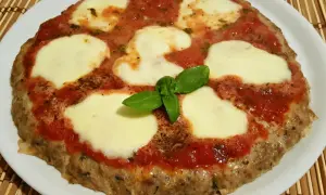 Bistecche alla pizzaiola con mozzarella filante e basilico fresco, un piatto gustoso e invitante.
