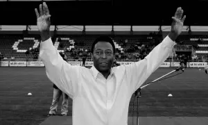 Pelé z uniesionymi rękami na tle stadionu. Jego wzrost i charyzma zawsze robiły wrażenie.