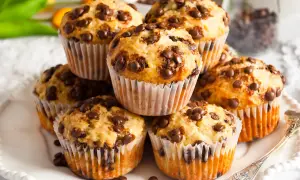 Stos muffinek bananowo czekoladowych, pachnących domem i słodyczą, gotowych do zjedzenia.