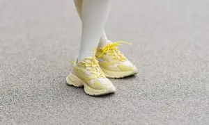 Żółte sneakersy na nogach w białych skarpetkach. Czy 36 rozmiar buta ile to cm?