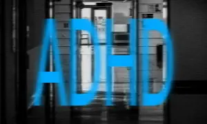 Blå texten "ADHD" över en suddig korridor. Bilden kan symbolisera kampen mot missbruk vid ADHD.