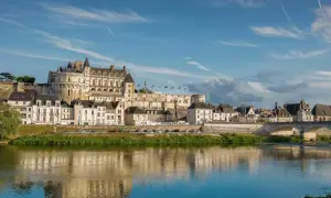Le majestueux château d'Amboise se dresse fièrement au-dessus de la Loire, ses tours et façades blanches reflétant la lumière du soleil sur l'eau paisible.