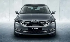 Szary Skoda Octavia sedan z chromowanym grillem i światłami LED, prezentujący się elegancko na tle betonowej ściany.